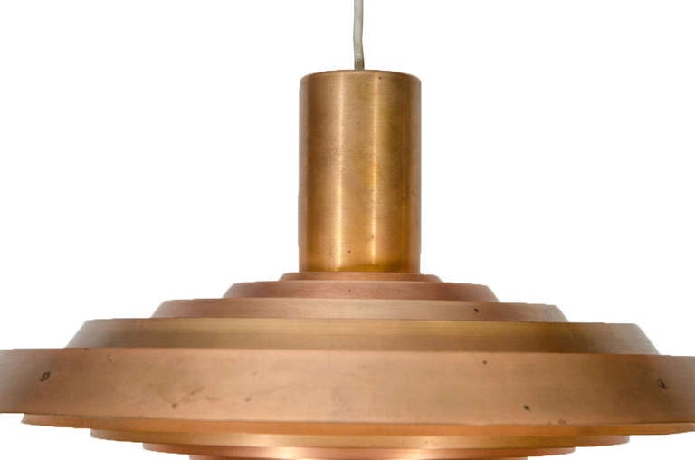 This Plate lamp is made of enameled copper, chrome-plated steel, and nylon. Manufactured by Louis Poulsen.