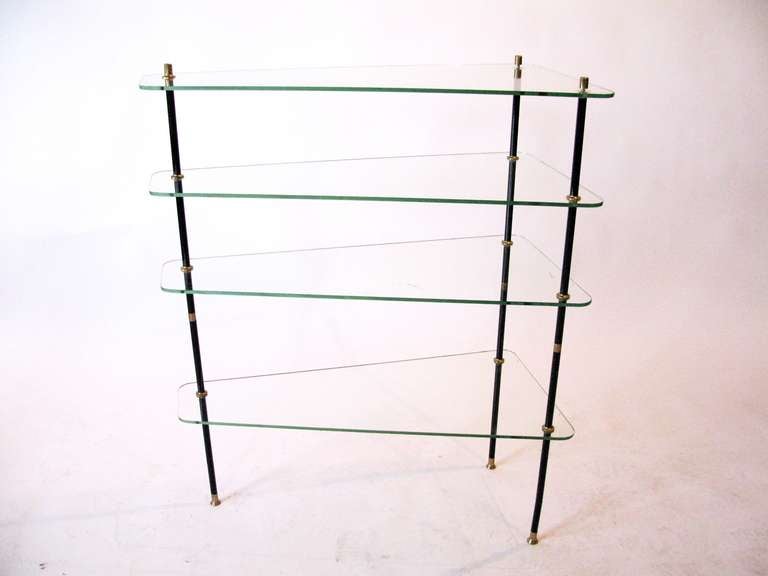 A mid century modern glass shelf having brass and steel supports, circa 1970.