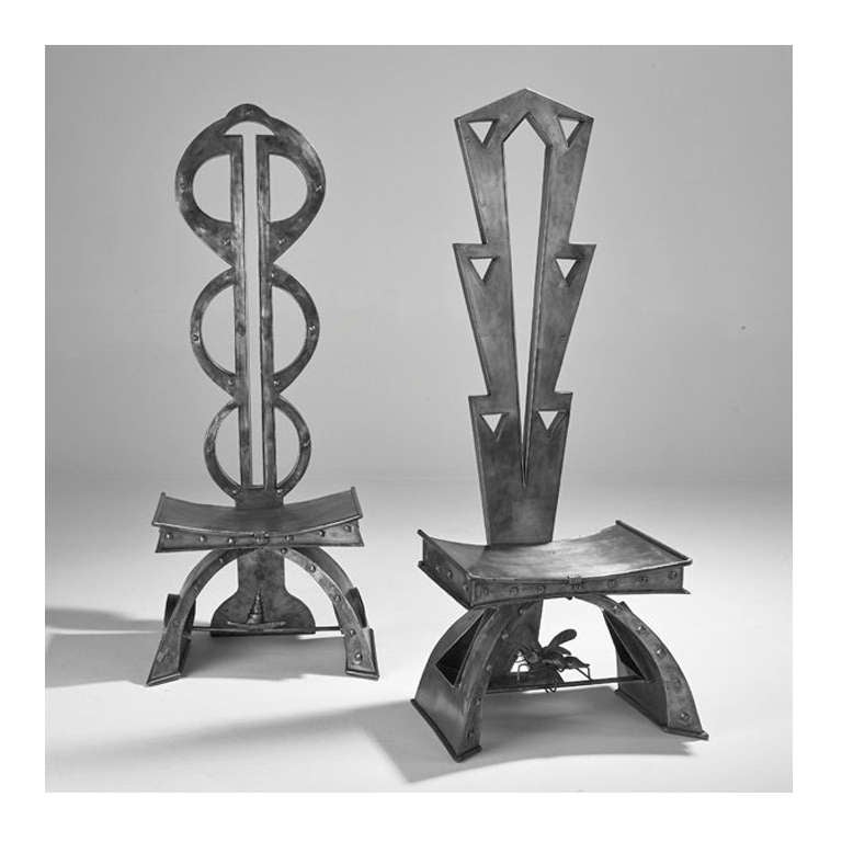 Two sculptural steel hall chairs with insect detail under each seat.
