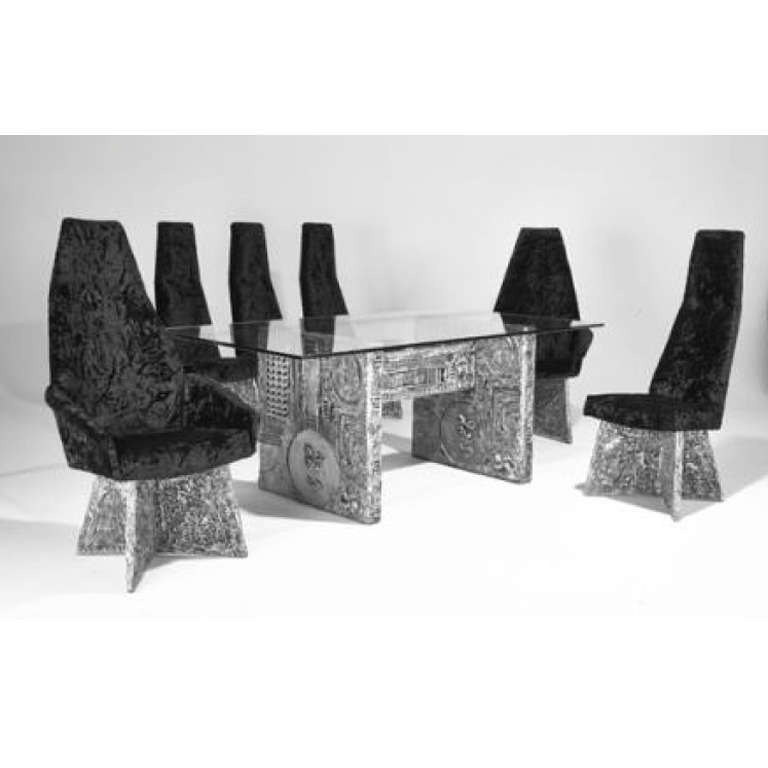 A unique dining set by the great Adrian Pearsall. Silvered composite with detailed carvings in all bases. Glass top dining table with two end armchairs and four dining chairs.

Dining set: table and six chairs two-arm and four-side. 
Table