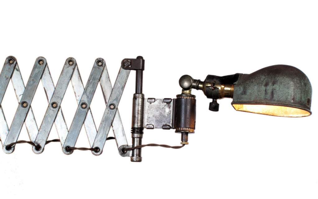 Superb scissor arm sconce with a distressed metal shade. The fully extended width length is 33