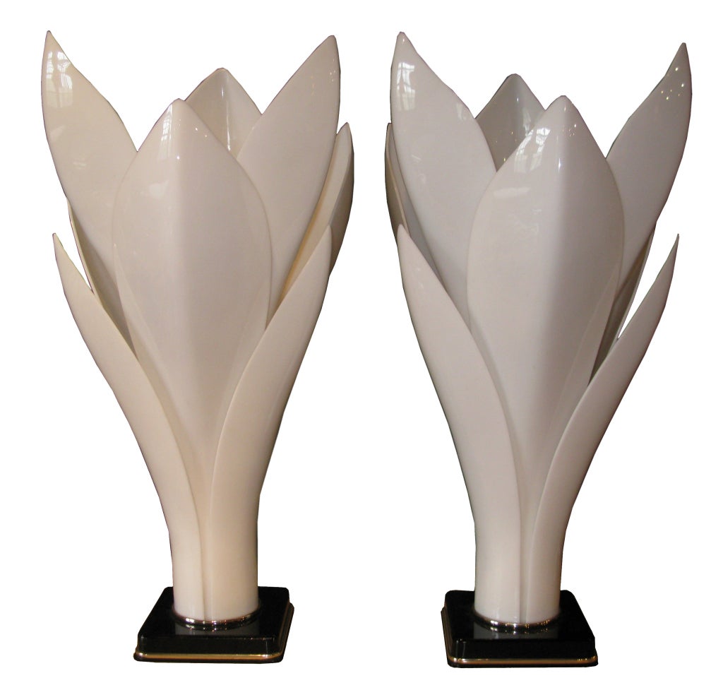 Striking pair of colored Lucite lamps in the shape of a lotus flower. White colored Lucite on black bases with small chrome detailing. Sold as pair. 1970's