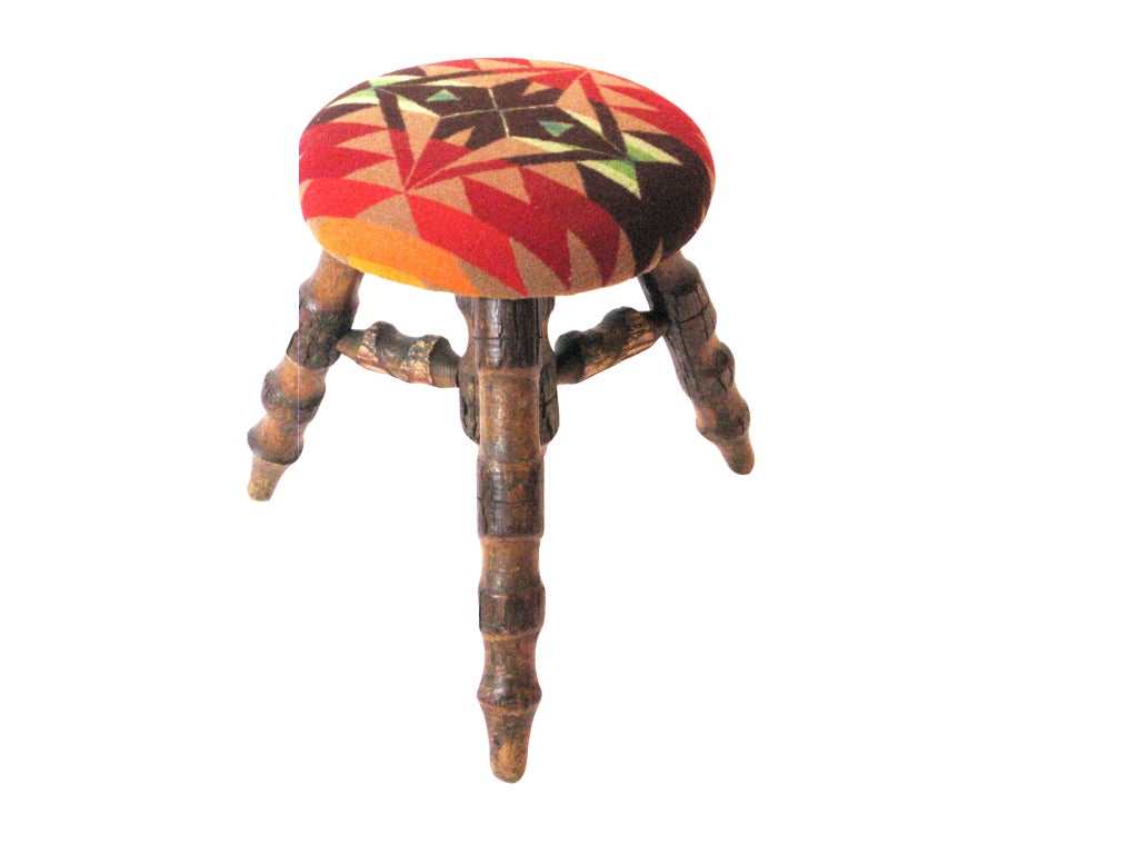 Hand carved wooden stool upholstered in Manderley native print wool fabric.