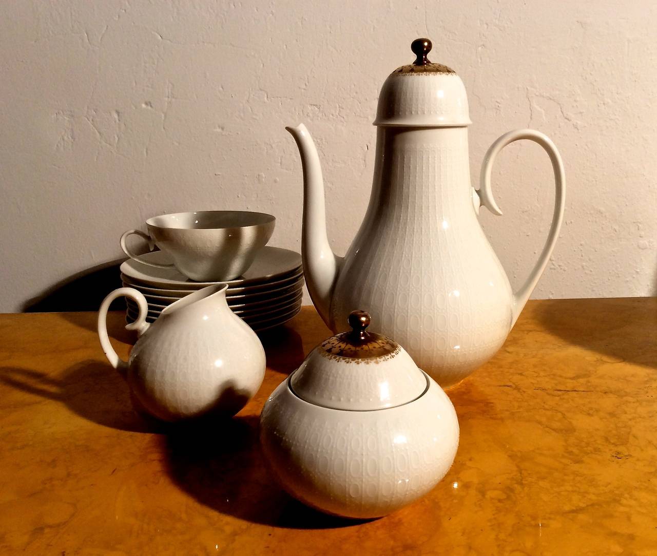 Porcelain coffee and dessert service for four in the Romanze pattern designed by Bjorn Wiinblad in 1959 and made by Rosenthal for their Studio-Linie in Germany. Set consists of coffee pot; creamer; sugar bowl; four cups and saucers; four small