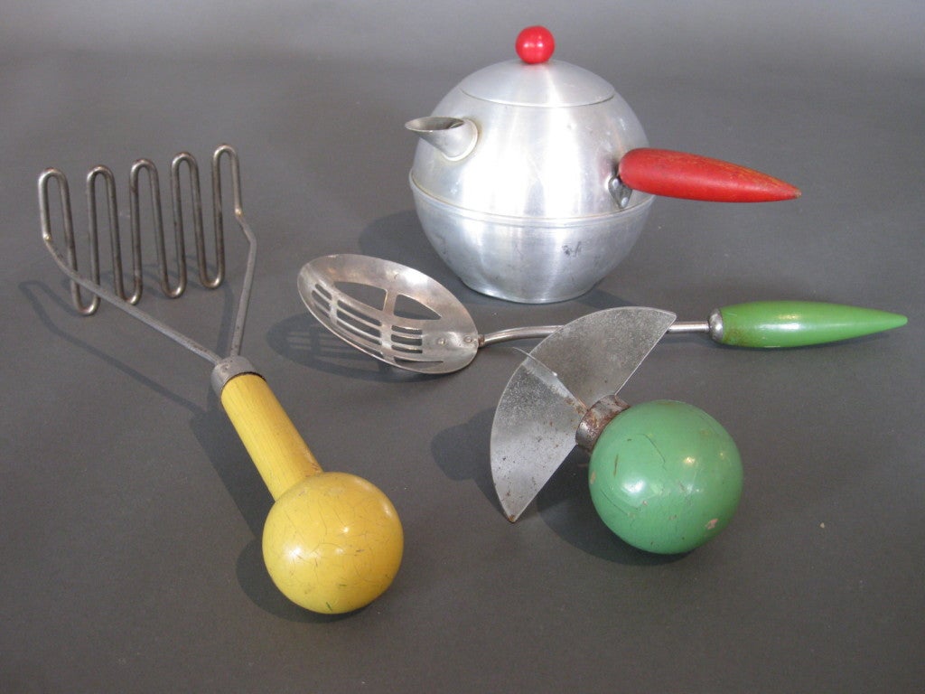 Collection of four kitchen utensils, a slotted spoon, potato masher, aluminum teapot,and herb mincer, designed by Henry Dreyfuss for Androck (spoon is marked) c.1930s. The slotted spoon and potato masher are both in the permanent collection of New