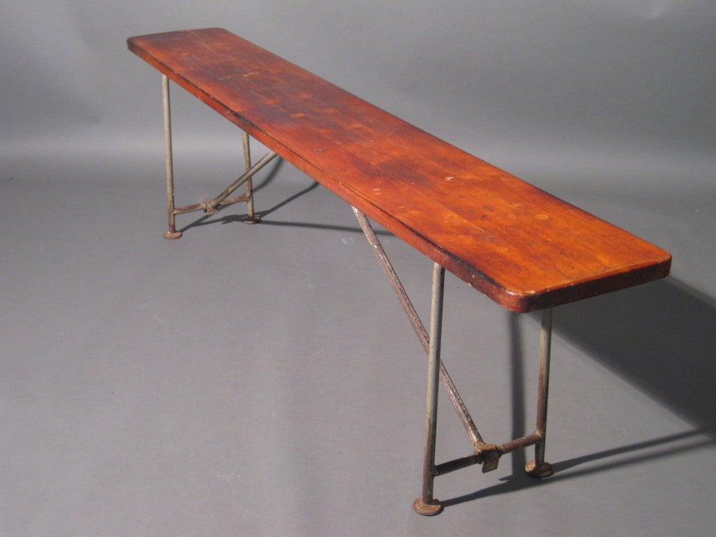 All original condition gymnasium bench with wood top and cast iron folding legs c.1920s.

WEEKLY DELIVERIES TO MANHATTAN FOR APPROVAL OR SALES. STANDARD DELIVERY FEE IS $150.