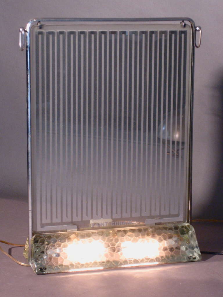 This is the early and more deluxe version of the Rene Coulon designed glass heater with illuminated base made in France by Saint Gobain and introduced at the Paris Industrial Expo of 1937. The heating part of the radiator and the lighting element of