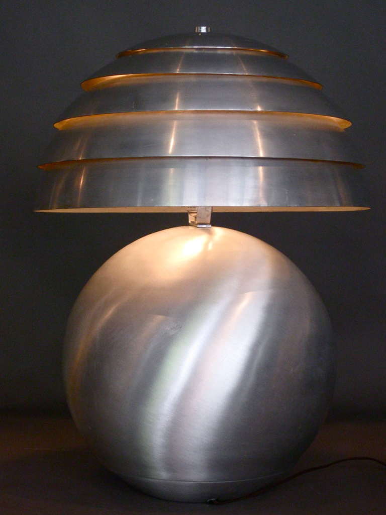 Large scale table lamp consisting of brushed aluminum ball shaped base with original louvered aluminum shade c.1940s.

WEEKLY DELIVERIES TO MANHATTAN FOR APPROVAL OR SALES. DELIVERY FEE IS $150