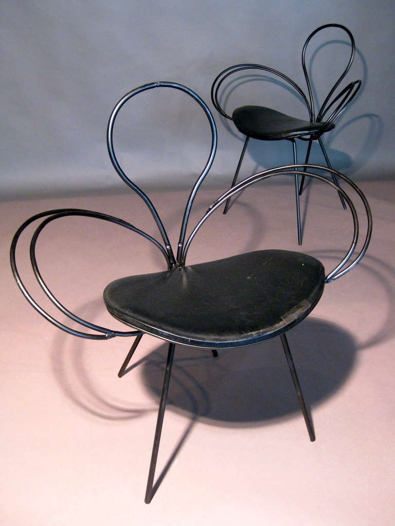 Pair of sculptural wrought iron chairs with curved seats made in Italy c.1950s. Chairs are slightly different as one is 30.25