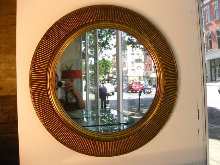 Round gilded and carved wood wall mirror made in Italy c.1950s.

WEEKLY DELIVERIES TO MANHATTAN FOR APPROVAL OR SALES. STANDARD DELIVERY FEE IS $150.