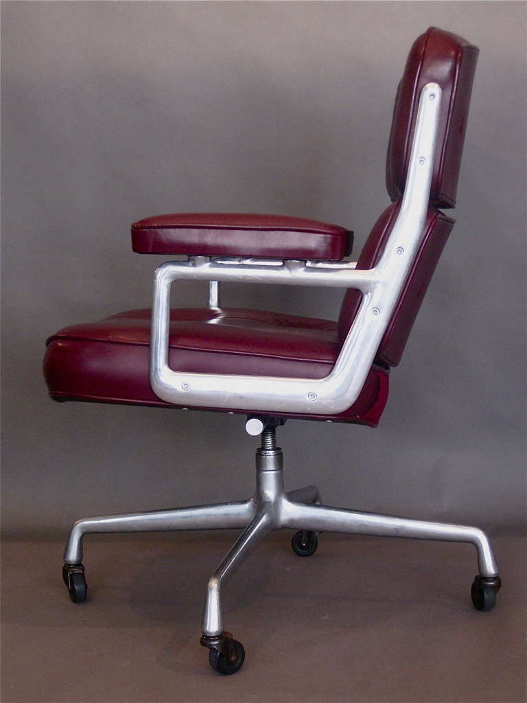 Desk chair with cast aluminum frame on casters and original cordovan colored leather designed by Charles Eames for the executive offices in the Time-Life building in New York City in 1960 and produced by Herman Miller. Beautiful patina on original