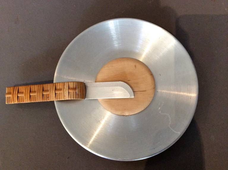 Spun aluminum cheese plate with inset round wood cutting surface and original matching cheese knife with reed handle designed by Russel Wright circa 1930s. Knife is 7.5