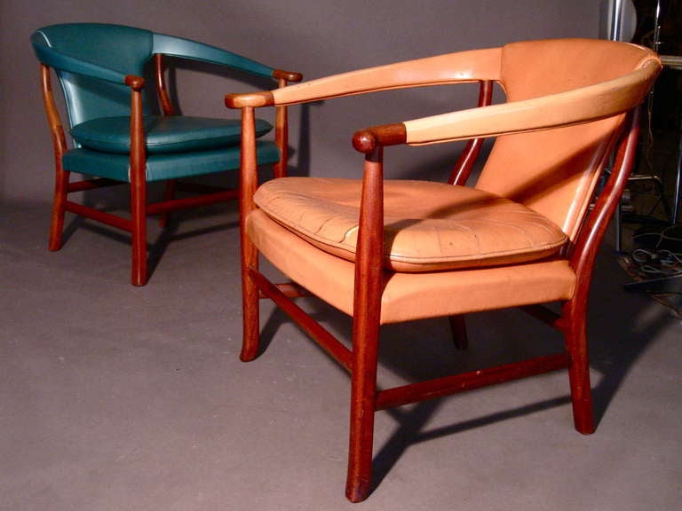 Rarely seen pair of sculptural teak lounge chairs made in Denmark circa 1950s and attributed to designer Jacob Kjaer. The salmon colored chair retains the original leather upholstery while the other chair was recently re-upholstered in vinyl. Both