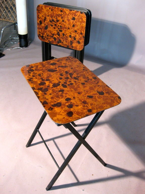 Set of four folding serving tables/snack tables with a faux tortoise shell laminate surface which hang on their original portable stand c.1950's. Some tables have their original label underneath calling the tables 