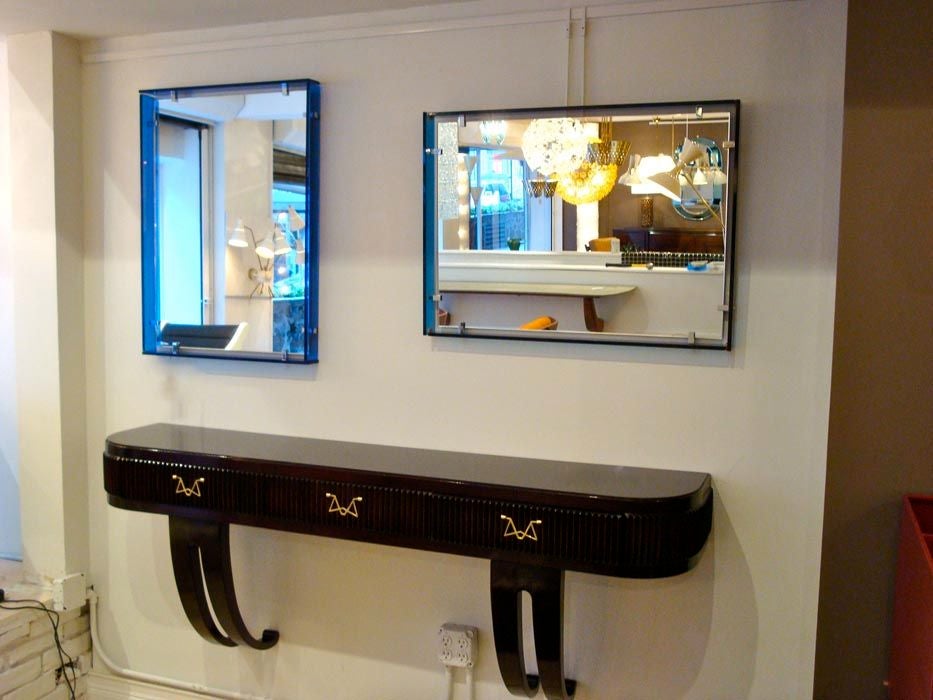 A pair of matched Mid-Century wall mirrors featuring a rectangular central mirror onto which is attached via two nickled clips along each side, a frame in blue glass which appears to float away from the central mirror. Fully documented. Fontana