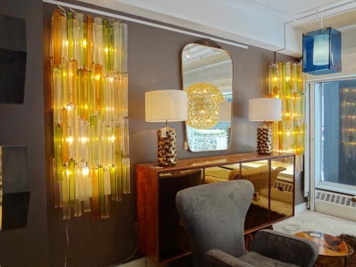 A pair of exceptional massive scaled chandelier wall sconces each featuring multiple interior light sources with a top painted square shaped steel hanging rack. From this hang very long light diffusing chains of glass each composed of an interior