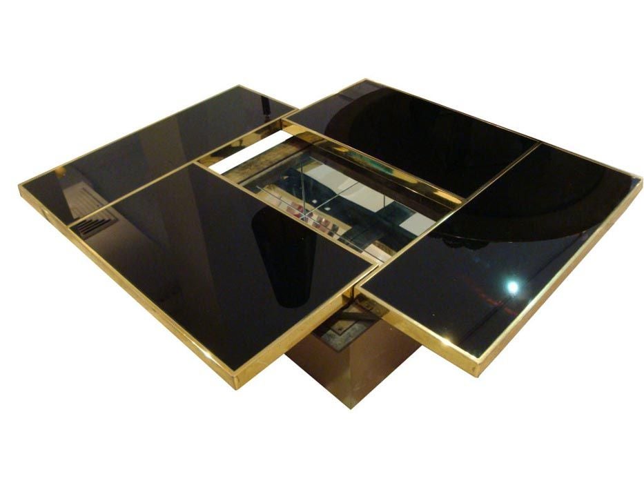 A rectangular cocktail table featuring a segmented brass framed top in black glass which sits on a square brass base. The top of the table slides open in all directions revealing a interior mirrored bar cabinet. In the style of Willy Rizzo, France