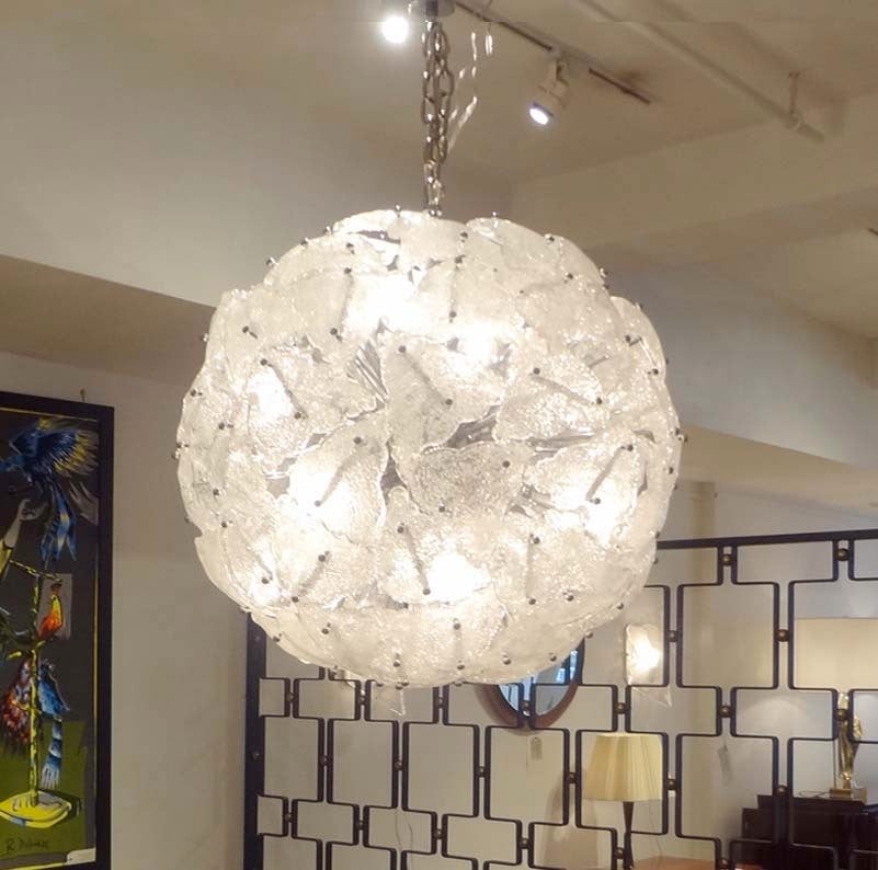A very large-scale mid-century sputnik shaped chandelier featuring a frame in polished chromed steel with multiple interior light sources onto which are attached multiple pieces of triangular-shaped textured hand made white opaque glass. By Mazzega,