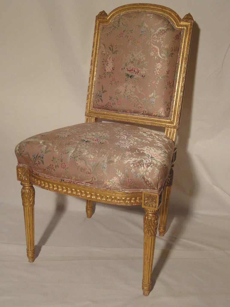 Pair of Circa 1900 French Giltwood Side Chairs. The beautiful gilt carving is well executed in the style of Louis XVI . The carving surrounding the Scalamandre upholstered back is of a bead, & bead & capsule design with an arched crest rail. The