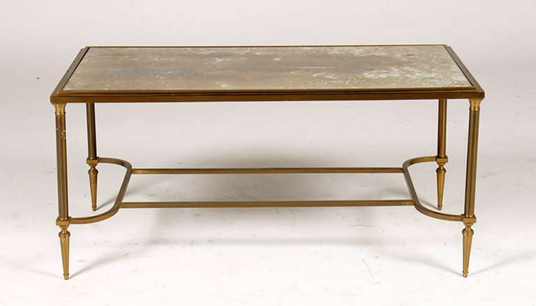 French bronze coffee table having inset gold mottled glass top supported by tapered legs and shaped stretcher.  Priced $3,200.00 as-is.