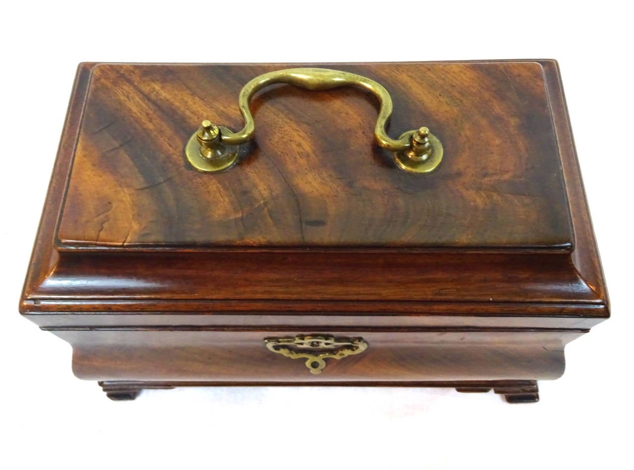 19th century English mahogany tea caddy with brass fittings, flip-top lid and three interior lidded compartments.