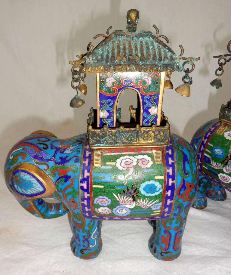 Small pair of mid-20th century cloisonné elephants from China in various shades of red, blue, and green with metal trim.
