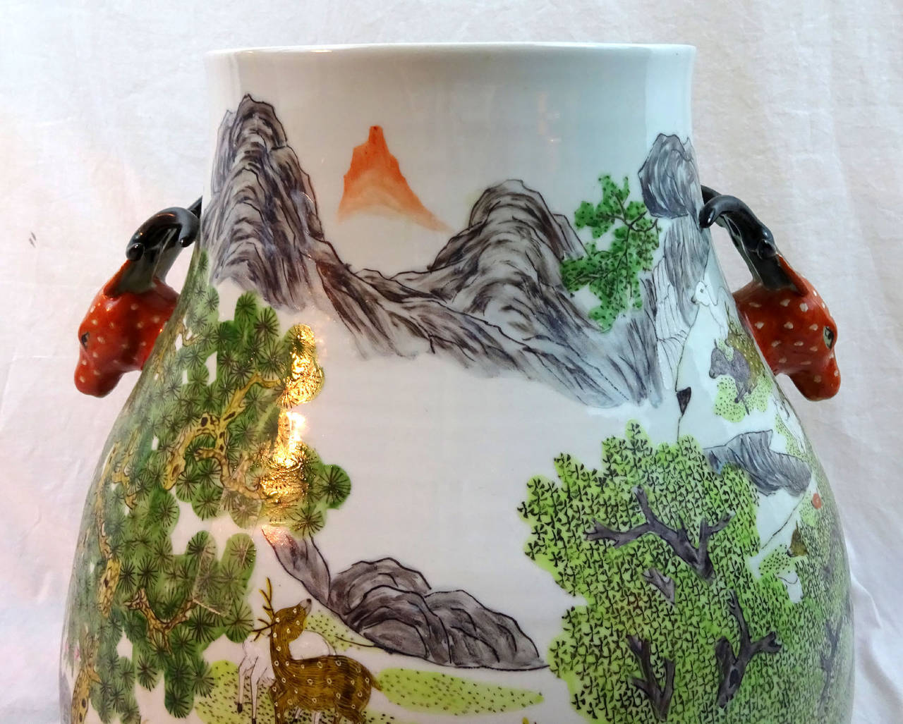 20th century Chinese porcelain jar with red deer head handles and a painted depiction of a nature scene, modeled after the antique.