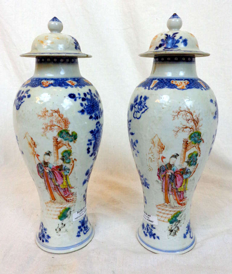 A pair of early 19th c. Chinese export porcelain lidded vases painted with blue flowers and Chinese figures.