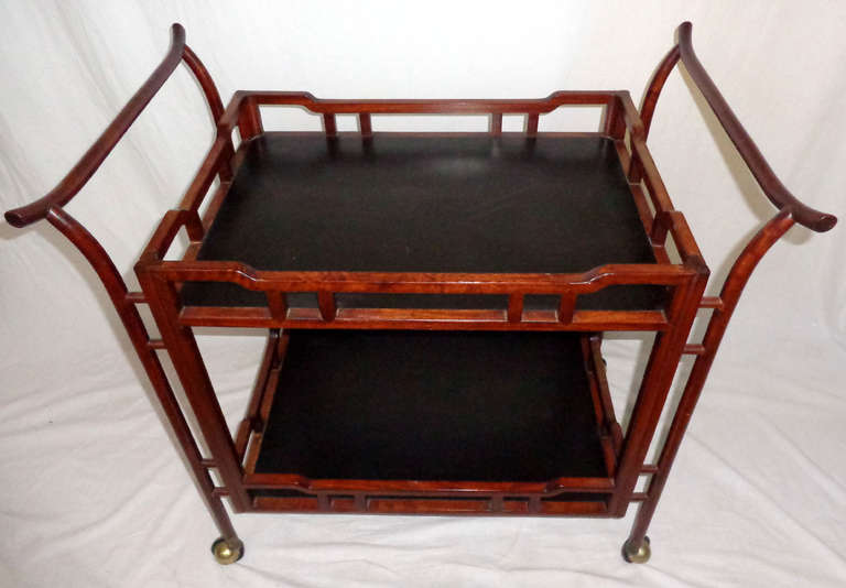 Chinese tea cart from the 1970's made from rosewood and resting upon brass casters.