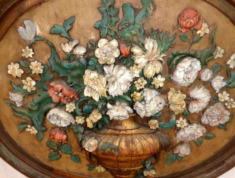 19th century French hand-carved and painted wood oval wall relief sculpture of flowers in an urn on stand.