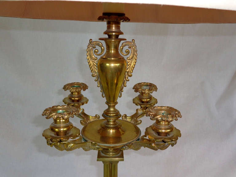 Brass Candelabra with four candle bearing arms surrounding a central urn that has been wired for electricity.