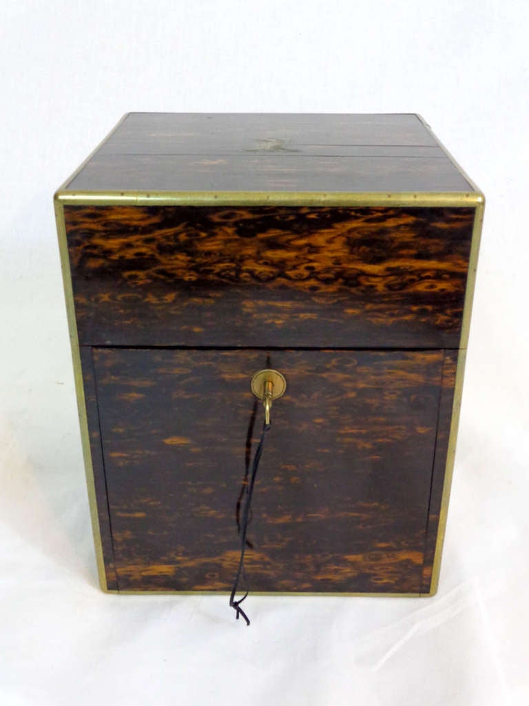 Tantalus box by Asprey & Co. of London containing four decanters on a removable tray.  Box of Calamander wood with brass mounts and lined with blue velvet.