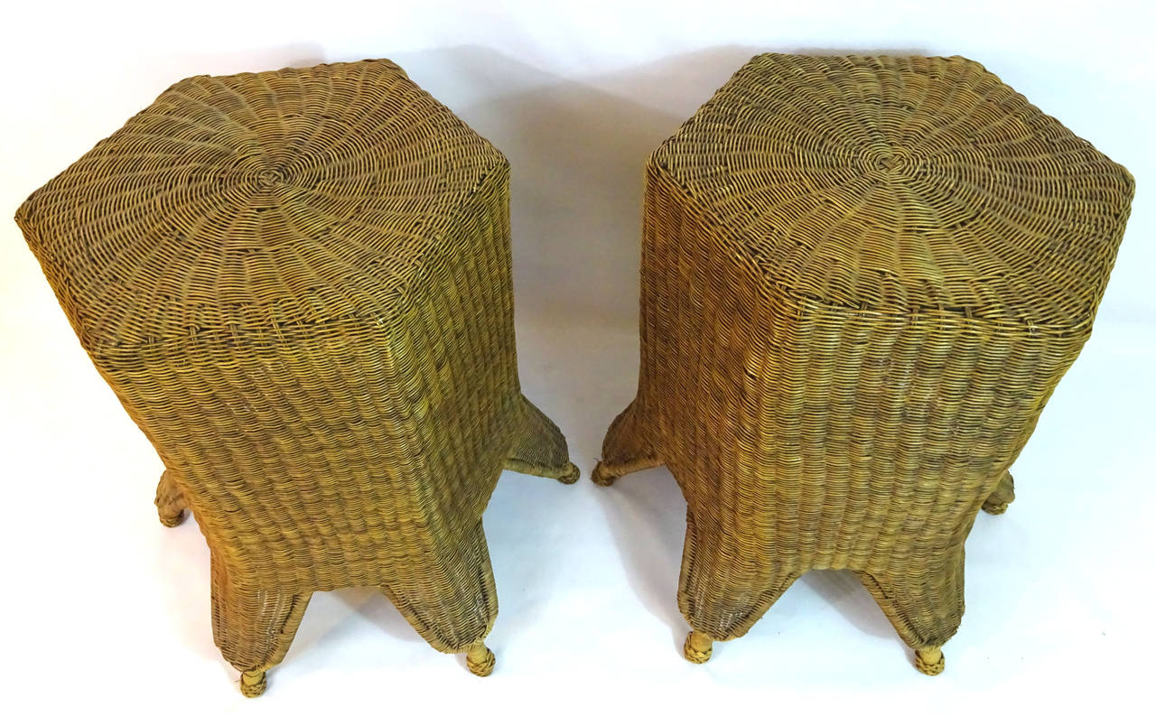 Pair of handwoven wicker hexagonal tables with splayed shaped legs and feet.