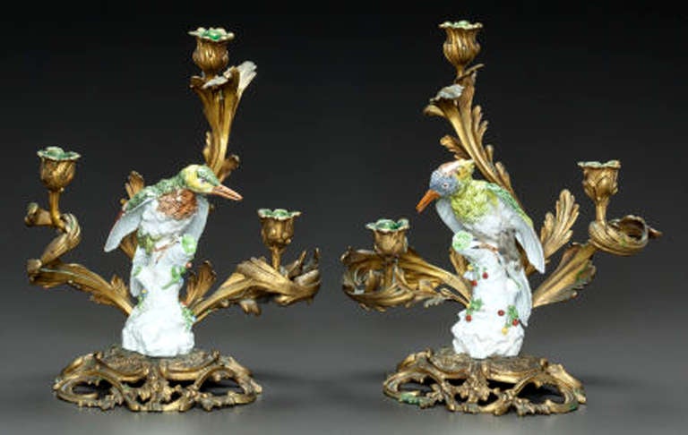 A pair of gilt bronze candelabra mounted with painted porcelain birds.
