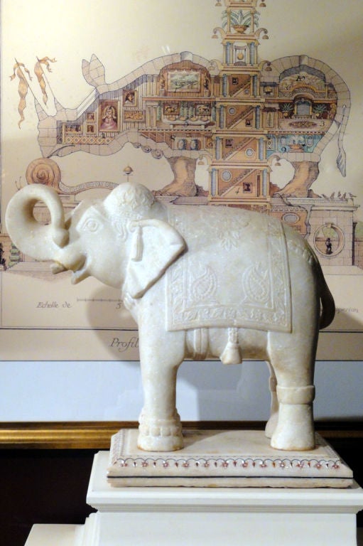 A Pair of Beautifully Proportioned & Carved White Marble Elephants with a well executed inlaid border on the bases. Befitting their high status, the elephants are carved with blankets, headdresses with ear tassels & other finery.
