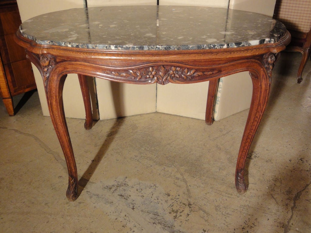 French Center Table with Marble Top of a simple yet elegant form, perfect also as a small dining table. Curving legs end in acanthus leaf decorated feet, sides carved with flowers, vines & a center acanthus leaf, & at each corner, a carved rose.