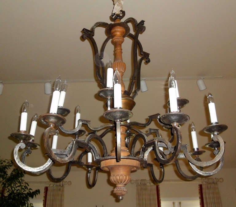 Louis XIV style 18-light chandelier made of iron, brass, and walnut.