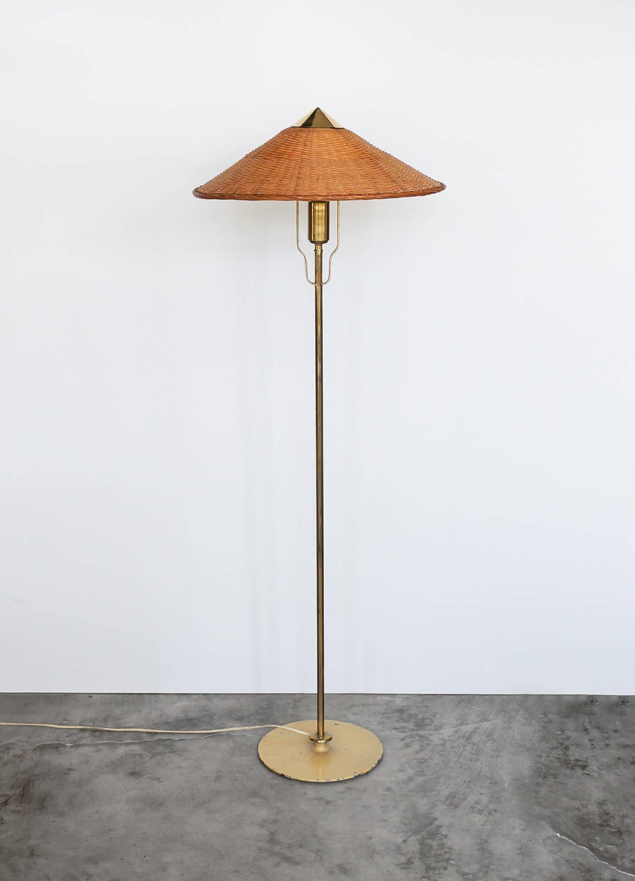 Paavo Tynell.

Floor lamp, model 5762.

Taito Oy.
Finland, late 1940s.
Brass, painted metal, iron, original wicker shade.

Measures: H 57 x W 17.7 x D 17.7 in.
H 145 x W 45 x D 45 cm.

Good original condition. Some wear due to it´s age on