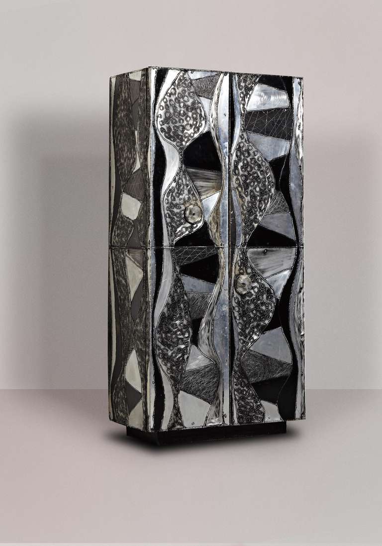 Paul Evans

Argente cabinet

Paul Evans Studio for Directional
USA, 1968 
welded aluminum, antiqued wood, leather wrap, welded steel 
36 w x 21 d x 76 h inches

Rare two door upright Argente cabinet concealing four adjustable shelves and