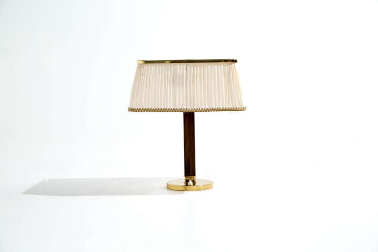 Paavo Tynell desk lamp, model 5066

Taito Oy, Finland, circa 1940s.
Perforated brass, brass, linen, mahogany.
Measures: 12.75 W x 12.75 D x 16.25 H inches.

Manufactured by Taito Oy, Finland. Underside impressed with Taito, Oy.