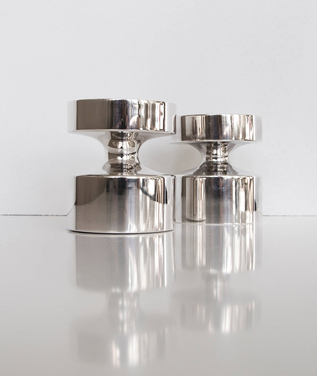 Eric Löfman. 

Pair of silver candleholders.

Designed in mid-1960s, 
Produced in 1967 respective 1977. 

Manufactured by MGAB Uppsala, Sweden. 

MGAB, Uppsala, Sweden. Marked with Swedish assay marks, year mark (one R9, one C10) and