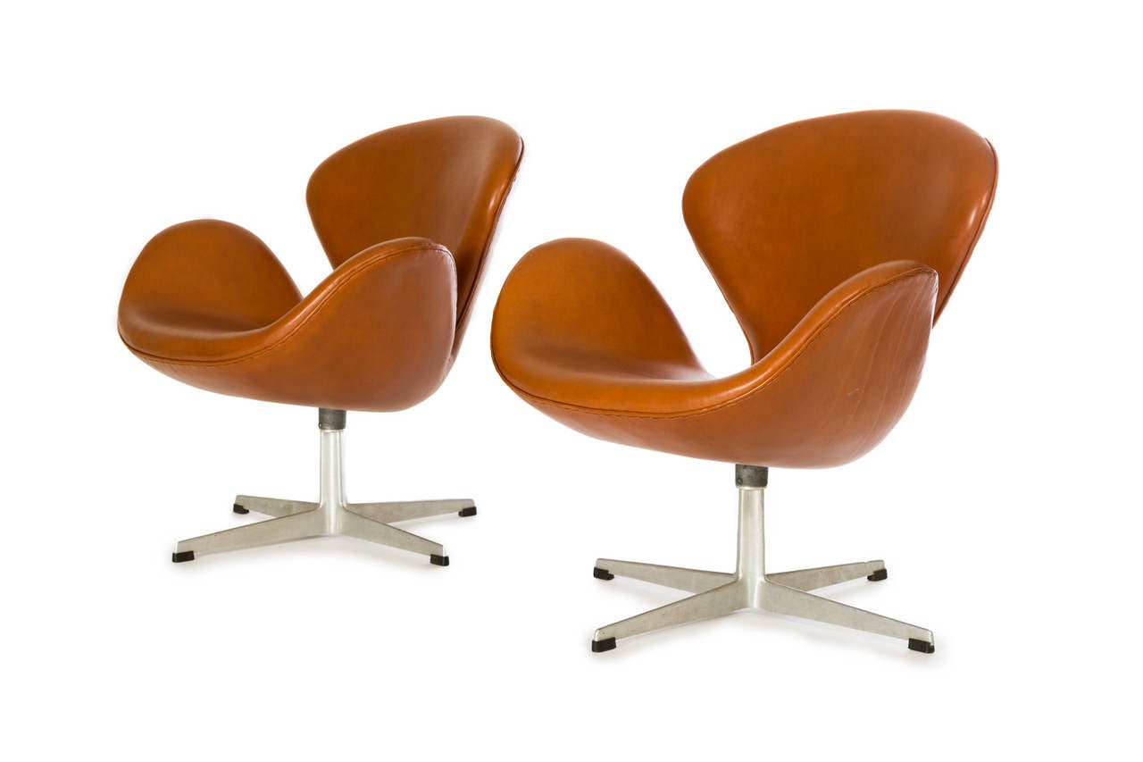 Arne Jacobsen.

Swan chairs (pair).

Fritz Hansen.
Denmark, 1957.
Leather, cast aluminum, plastic.
Measures: 30 W x 26 D x 31 H inches.

Pair of leather swan chairs with early flute base.