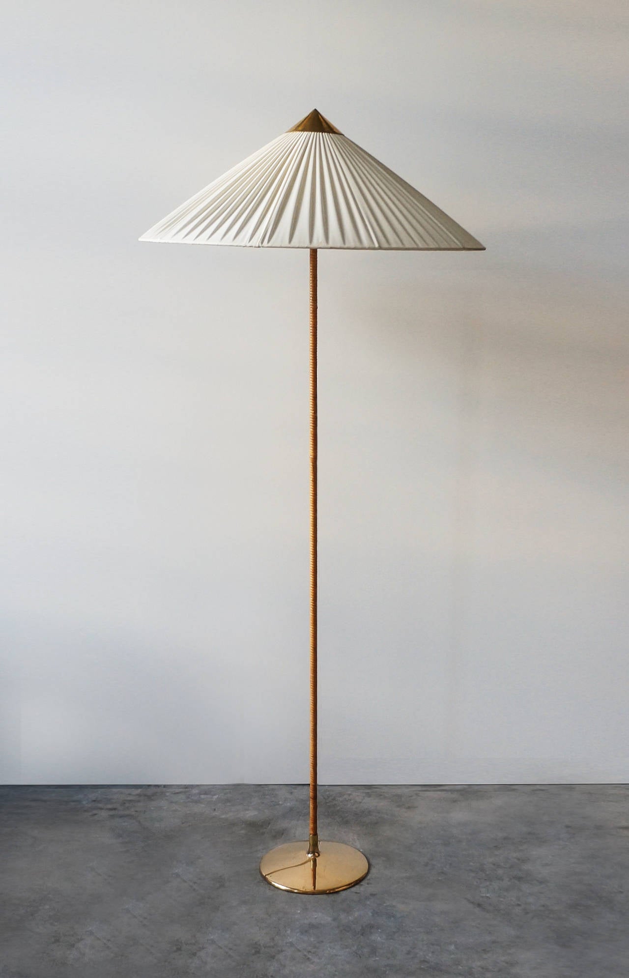 Paavo Tynell floor lamp.

Taito Oy.
Finland, circa 1940s.

Solid brass, metal, rattan and original silk shade.
Measures: 24 diameter x 60 H inches.

Model nr: 9602, designed and manufactured, circa 1940s. 
Manufactured by Idman, Finland.