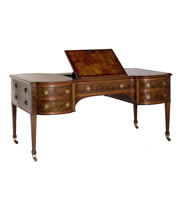 A rare and unusual George III mahogany hourglass shaped partner's desk with bowed ends.  The inset leather top centering a hinged reading easel , the body with a central drawer flanked by a further pair of flame figured drawers<br />
on both sides;