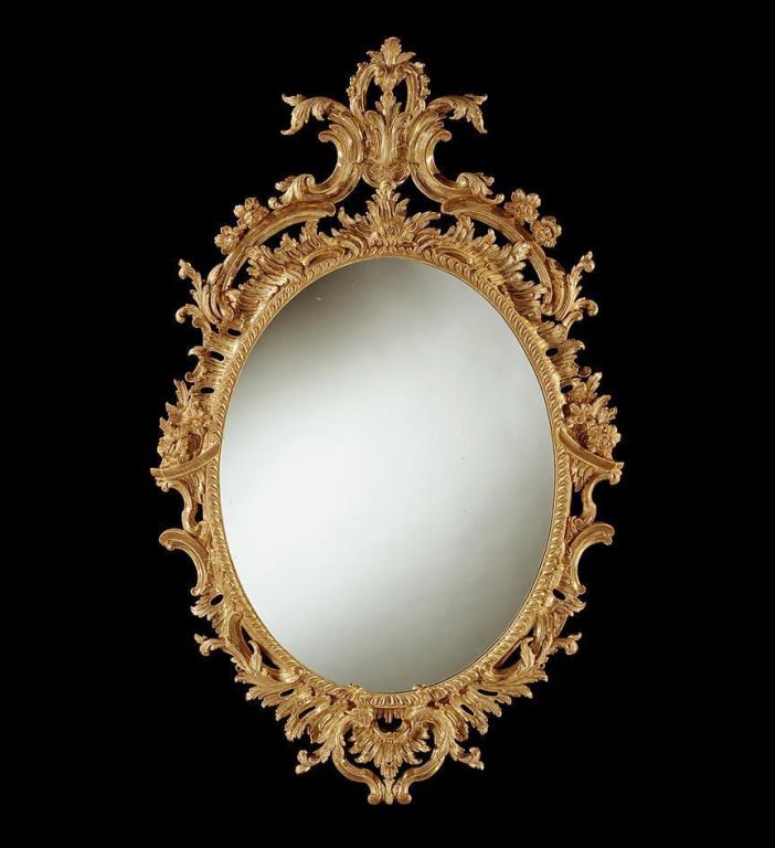 A fine George II carved giltwood oval mirror in the Chippendale taste, the crest with a pierced leafy C-scroll cartouche, the <br />
frame with overall foliate and C-scroll decoration.  The mercury plate is 19th century.