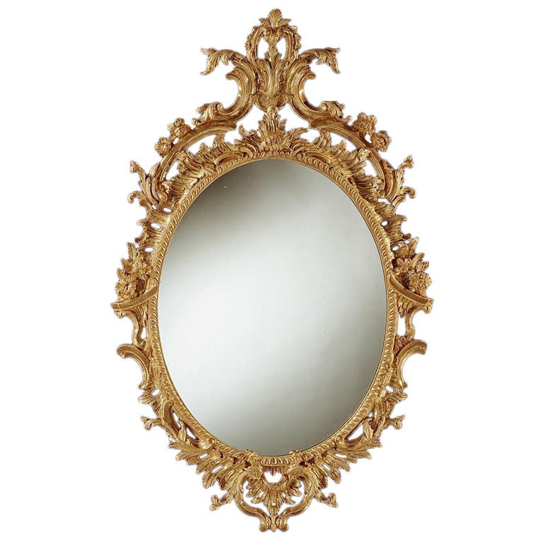 A fine George II carved giltwood oval mirror. For Sale