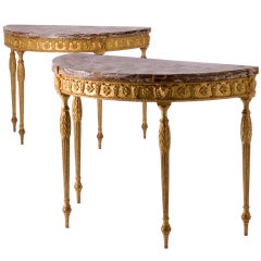 A pair of George III marble-topped  demi-lune console tables.