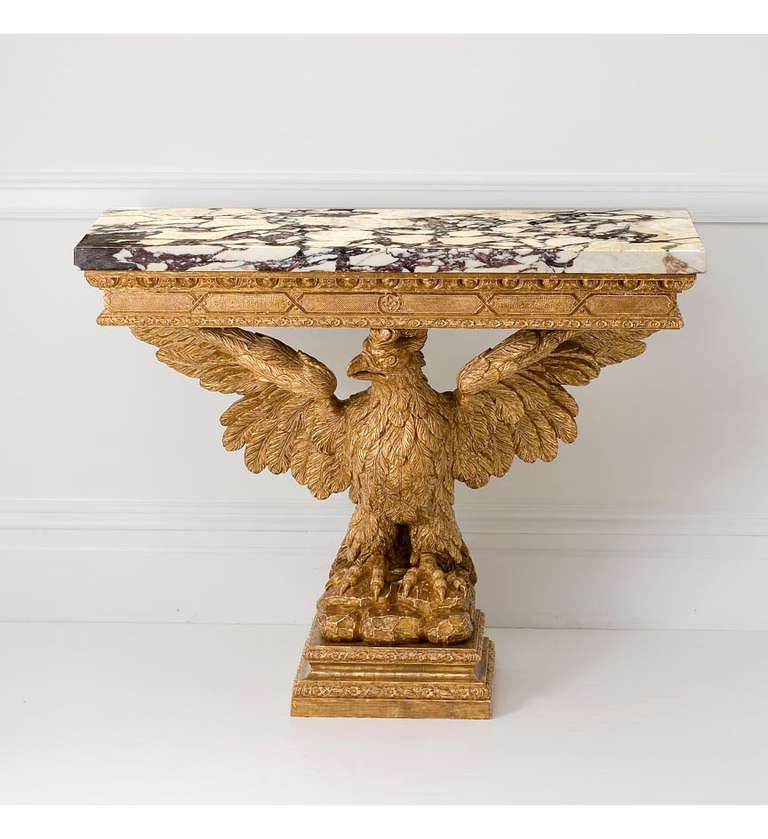 A George II giltwood marble-topped console table in the form of a wingspread eagle with a breche violet marble top.