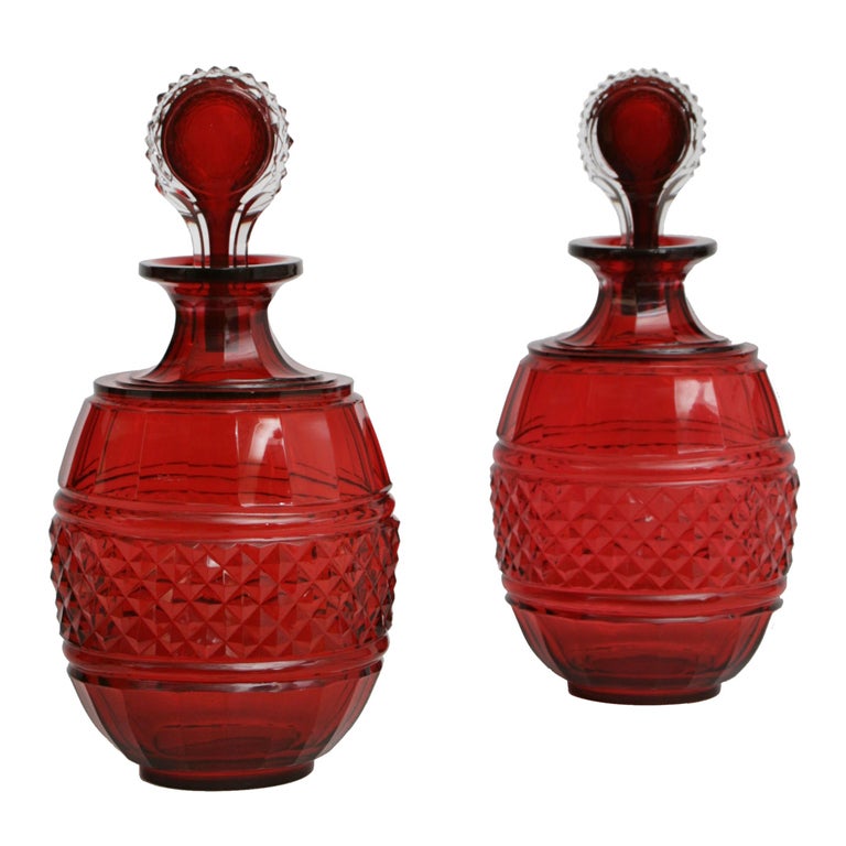 A pair of red glass decanters. For Sale