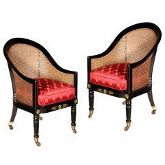 A pair of Regency ebonized cane-filled tub chairs.